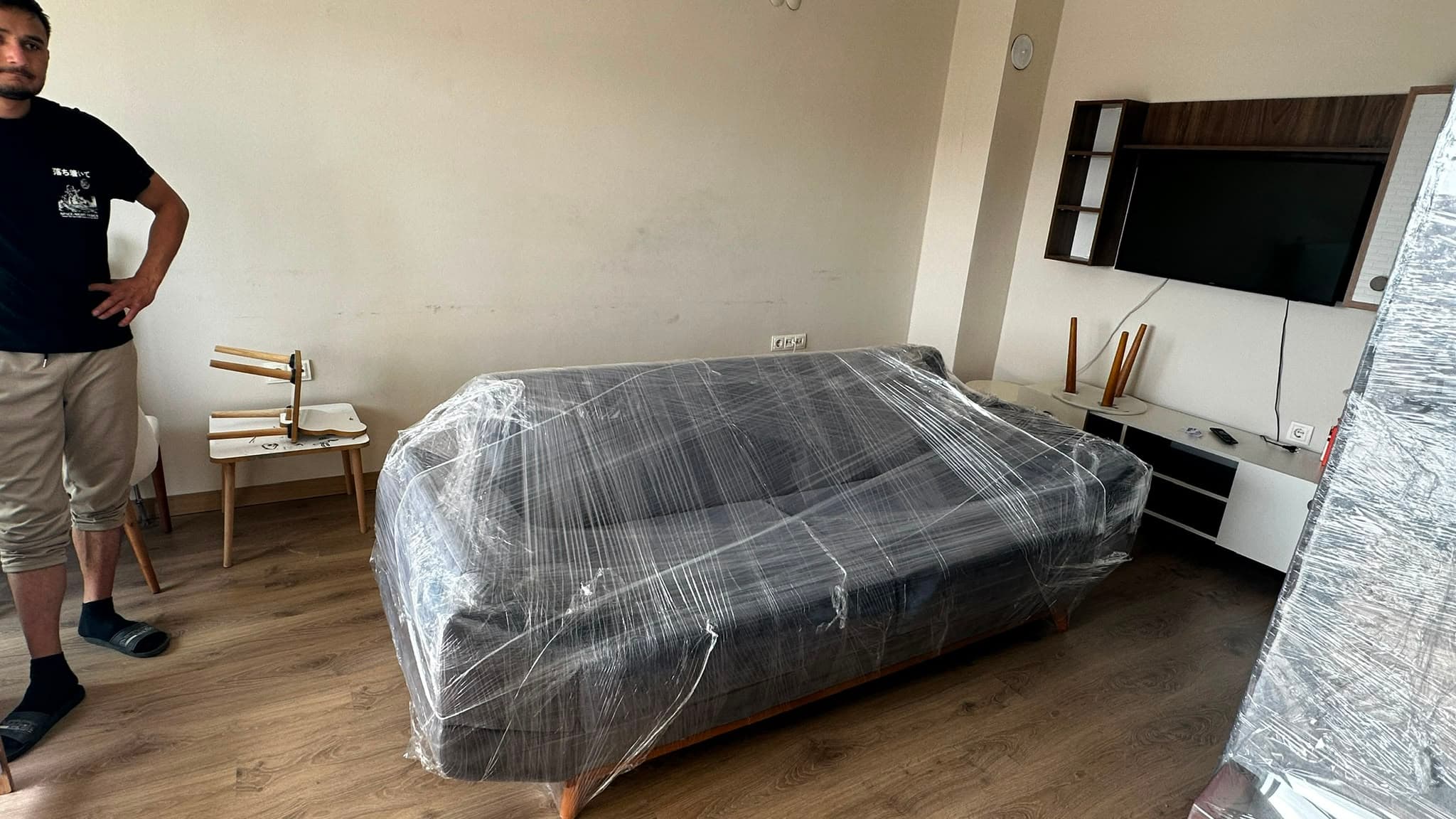Taşınma Öncesi Yapılacaklar Listesi | Uşak Evden Eve — Nakliyat ekip üyesi paketli koltuk teslim sahnesinde — blog görseli